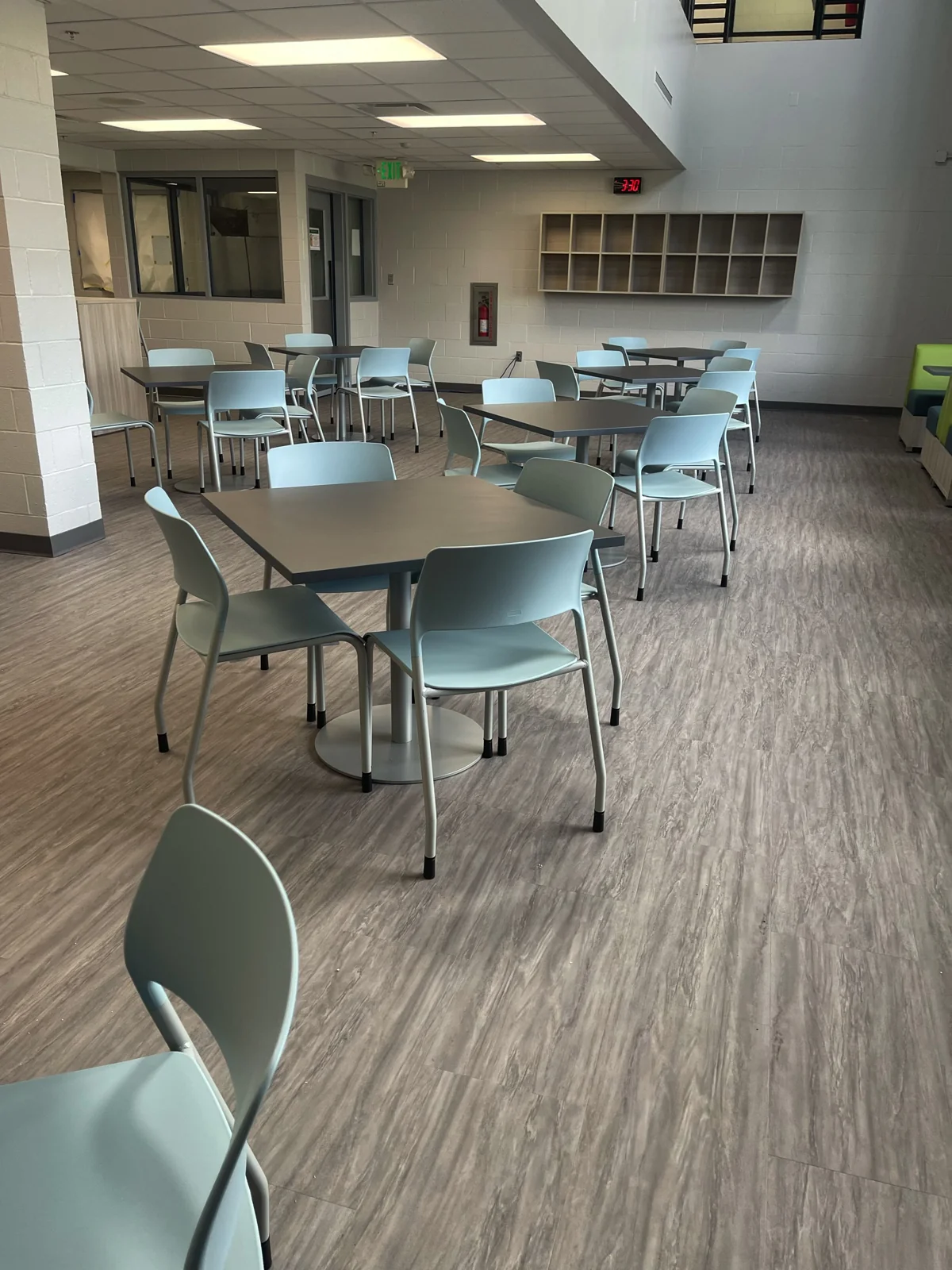 Café tables and light blue chairs in a bright shared space