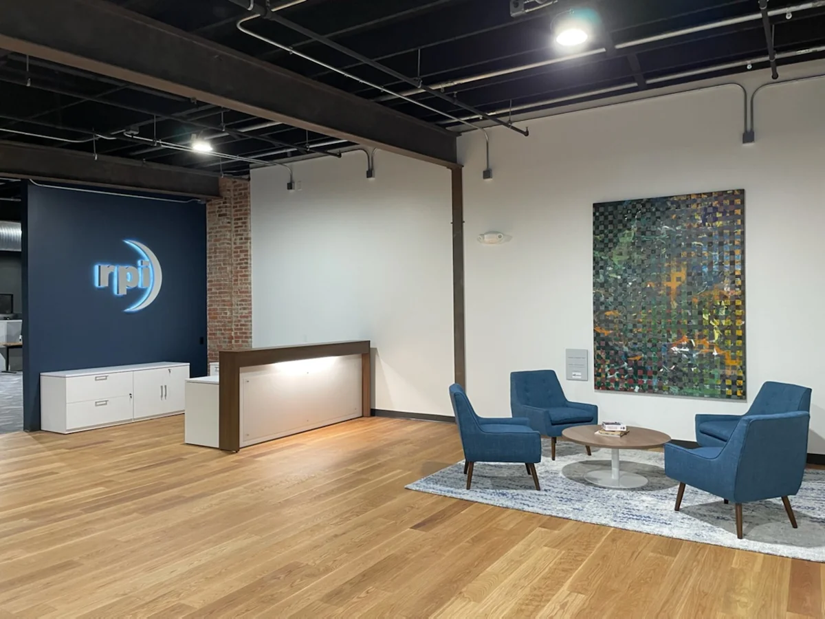 Reception desk and blue lounge seating in a finished commercial interior