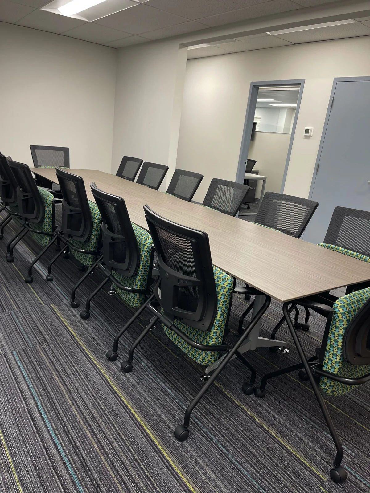 Conference table and black task chairs in a completed WURKSPACE meeting space